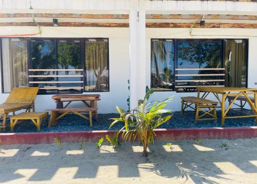a group of tables and benches on a patio at Bolo Hills Beach Club And Residence in Alaminos