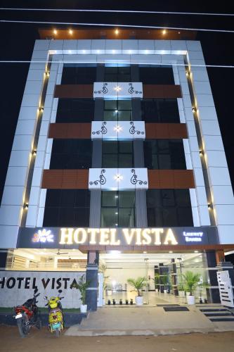 a hotel with a motorcycle parked in front of it at Hotel Vista Airport Zone in Shamshabad