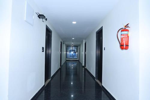 a corridor of a building with a fire extinguisher on the wall at Hotel Vista Airport Zone in Shamshabad