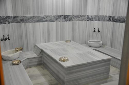 Hotel Grand Eregli في ايريجلى: حمام أبيض مع حوض ومرحاض ومغسلة
