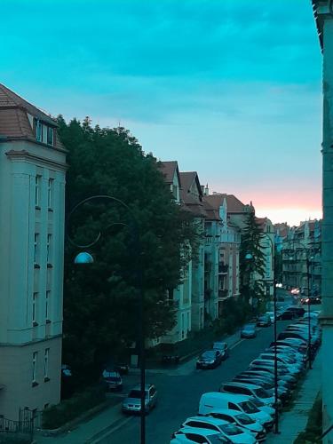 a city street with cars parked in a row at Yoda house in Legnica