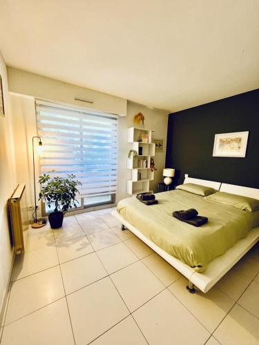 une chambre avec un grand lit et une fenêtre dans l'établissement Grand T2 lumineux, avec vue et piscine, à Toulon