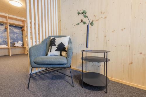 a blue chair and a table in a room at Frutt Living in Kerns