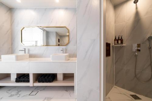 a bathroom with two sinks and a mirror and a shower at Gwangalli Hotel primavera in Busan in Busan
