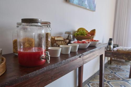 een tafel met kommen eten en een pot vloeistof bij Artist Beach House in Morjim