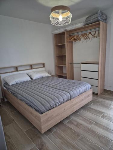 une chambre avec un grand lit et un parquet dans l'établissement T2 4 pers, rénové en bord de plage , clim et parking classé 2 étoiles, à Sète