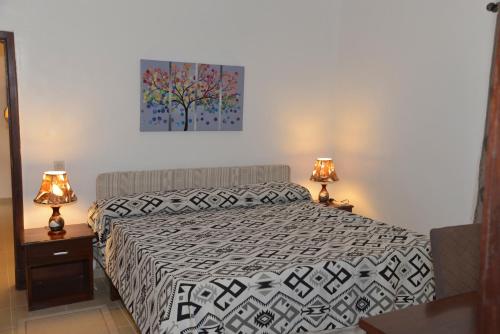 a bedroom with a bed and two lamps at Hotel la Coccinelle in Bamako