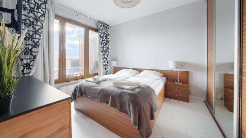 a bedroom with a bed and a large window at Olympic Park I, Sun & Snow in Kołobrzeg