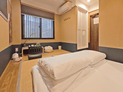 a bedroom with a bed and a window at 杉ー着物の宿 in Kyoto
