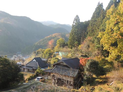 a group of houses on a hill with trees at Kamakurayama Farm - B&B Satoyama in Uda