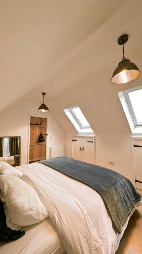 a bedroom with a large bed with two skylights at Plum Cottage Somerset in Wells