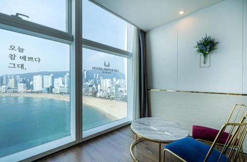 a room with a table and chairs and a large window at Gwangalli Hotel primavera in Busan in Busan