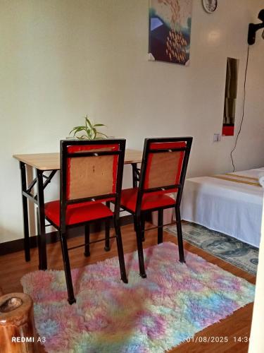 a dining room table with two chairs and a table with a rug at golden anchor lodge in Coron