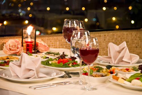 a table with plates of food and glasses of wine at Grand Hotel Gaziantep in Gaziantep