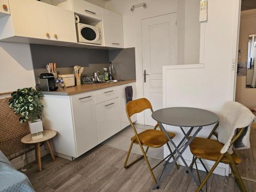 a kitchen with a table and chairs in a room at Studio 2 personnes Vue Mer Climatisé Linge Maison in Le Lavandou