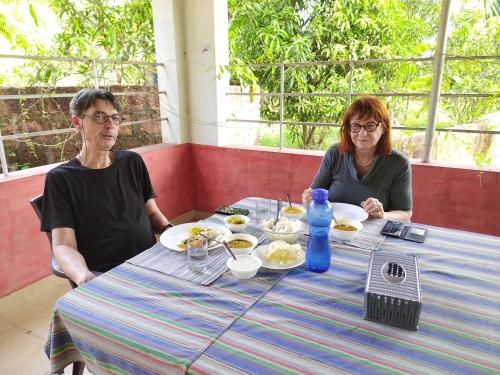 two women sitting at a table eating food at Kannur west beach homestay in Kannur