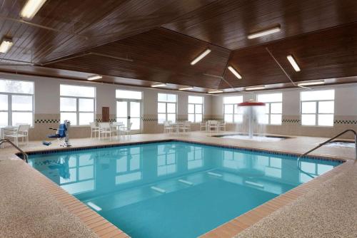 a large swimming pool with blue water in a building at Country Inn & Suites by Radisson, Houghton, MI in Houghton