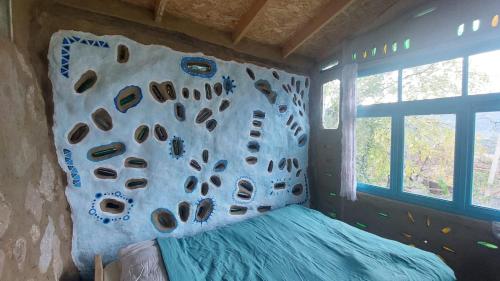 a rock wall in a room with a bed at The house in the village in Tirana