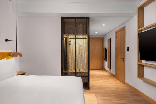 a bedroom with a bed and a flat screen tv at Hilton Garden Inn Baku in Baku