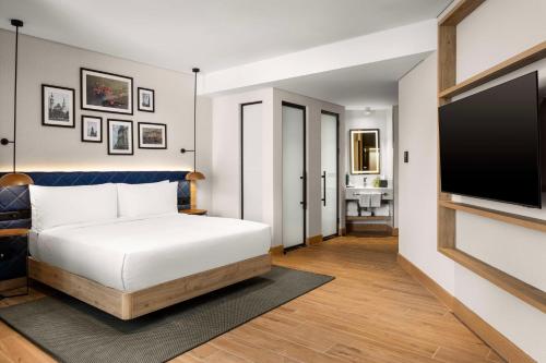 a bedroom with a bed and a flat screen tv at Hilton Garden Inn Baku in Baku