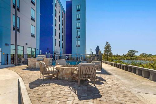 a patio with chairs and a table in front of buildings at Comfort Suites Titusville near Kennedy Space Center in Titusville