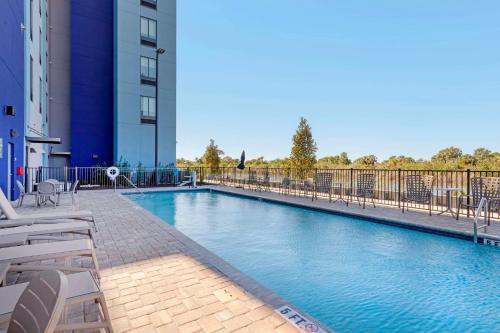 a large swimming pool with chairs and a building at Comfort Suites Titusville near Kennedy Space Center in Titusville
