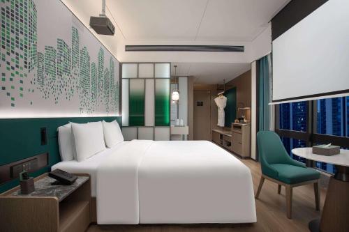a bedroom with a large white bed and a desk at Wingate by Wyndham Zhuhai Gongbei Port in Zhuhai