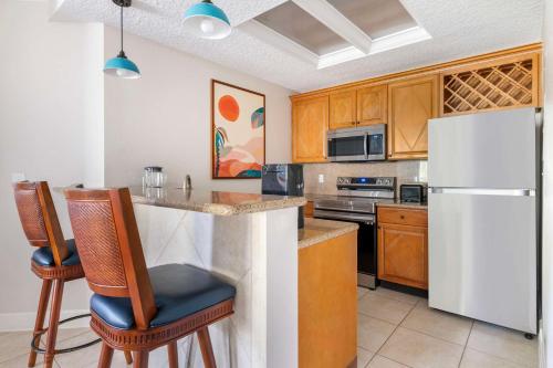 a kitchen with a white refrigerator and wooden cabinets at Hilton Vacation Club Cypress Pointe Orlando in Orlando