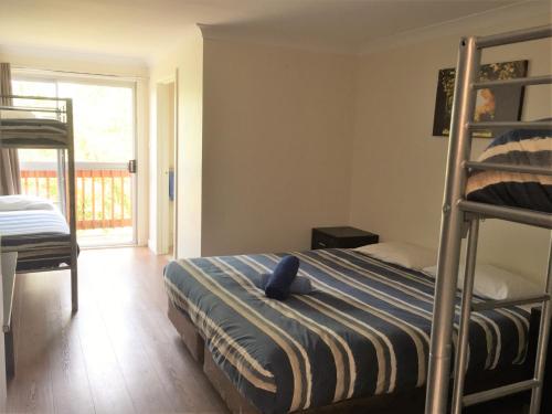 a bedroom with a bunk bed and a balcony at Siesta Villa in Jindabyne
