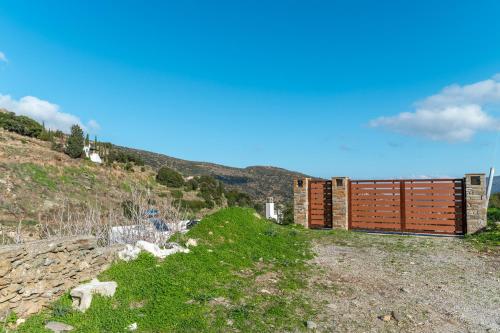 a building on top of a hill with green grass at Moraki Apartment 1 Andros in Korthi