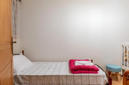 a bedroom with a bed with a pink pillow on it at Moraki Apartment 1 Andros in Korthi