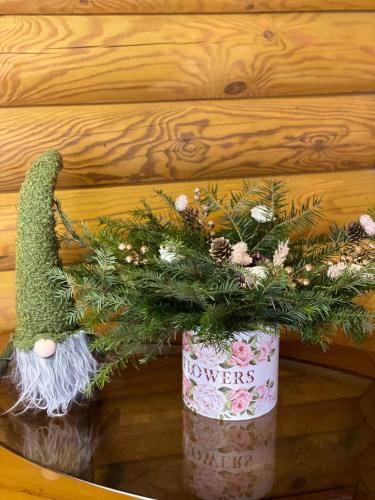a christmas wreath in a flower pot on a wall at Еко котедж Яблуницька троянда in Yablunytsya