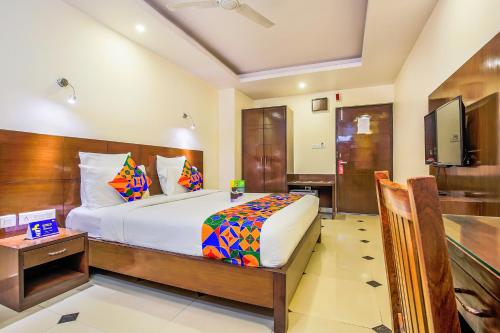 ジャイプールにあるFabHotel Tipsyy Inn Suitesのベッドとテレビがあるホテルの部屋