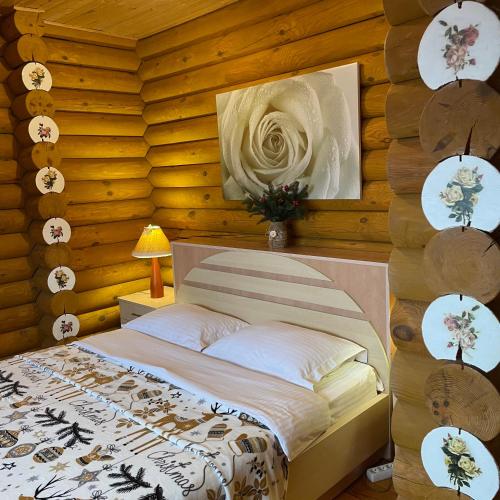 a bedroom with a bed in a wooden wall at Еко котедж Яблуницька троянда in Yablunytsya