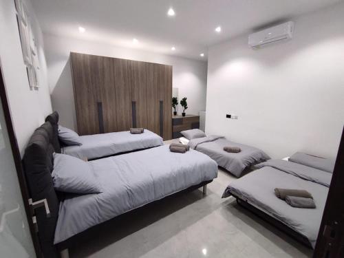 a bedroom with three beds in a room at Flat 1, spacious 3 bedroom near Beaches and Countryside in Mġarr