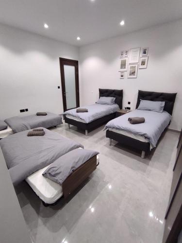 a room with three beds and a mirror at Flat 1, spacious 3 bedroom near Beaches and Countryside in Mġarr