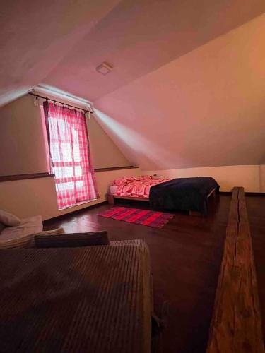 a attic room with a bed and a window at Apartment HD Liptovská Teplička in Liptovská Teplička
