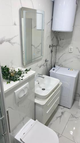 a white bathroom with a toilet and a sink at Apartment seafront Juraj in Tribunj