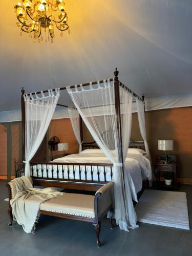 a bedroom with two beds and a chandelier at MASAI - Tented Villa Resort, Lonavala in Āmbavna