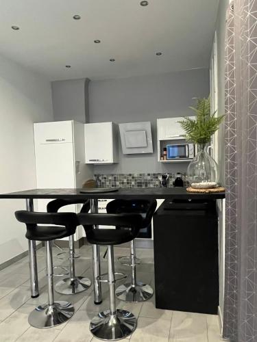 une cuisine avec un comptoir noir et des tabourets de bar noirs dans l'établissement Plage des Catalans - Palais du Pharo - Vieux Port, à Marseille