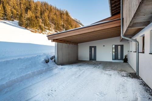 a house with a snow covered driveway at Hinterschiesslinghof in Scheffau am Wilden Kaiser