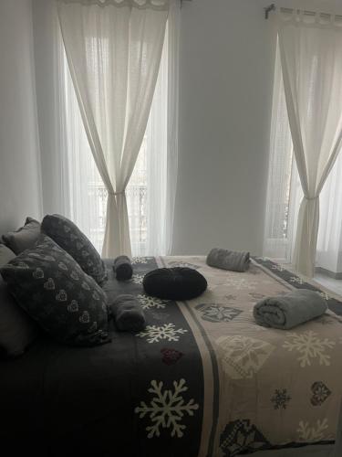 - un lit avec des oreillers dans une chambre dotée de fenêtres dans l'établissement Plage des Catalans - Palais du Pharo - Vieux Port, à Marseille