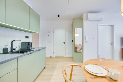 a kitchen with a wooden table and white cabinets at ReVital Mechelinki by Homeprime Parking Free in Mechelinki