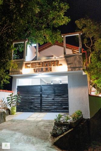 ゴールにあるCeygal Villa Galleの夜間の黒いガレージドア付きの家