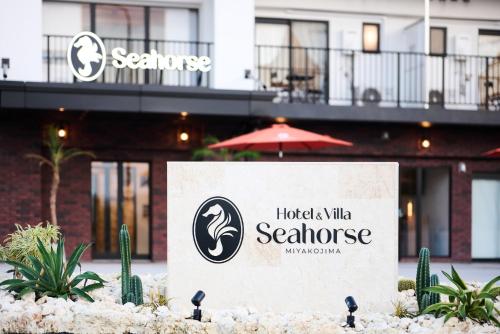 宮古島にあるHotel & Villa Seahorse MIYAKOJIMAの建物のあるホテル前の看板