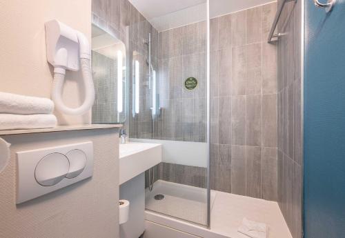 a bathroom with a shower and a toilet and a sink at B&B HOTEL Bordeaux Mérignac Cadera Aéroport in Mérignac