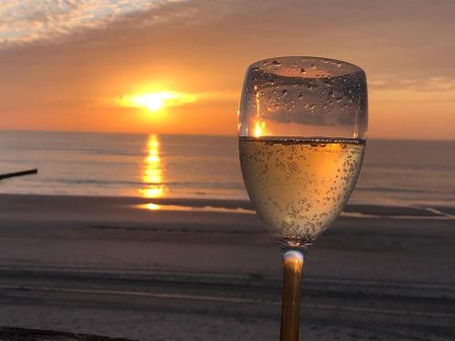 a glass of wine on the beach with the sunset at Wohnung-Moewe-2 in Westerland (Sylt)