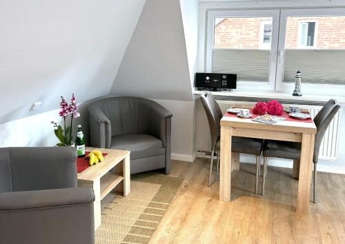 a living room with a table and a chair at Wohnung-Moewe-2 in Westerland (Sylt)