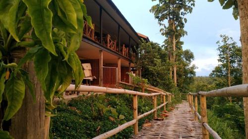 a bamboo walkway leading to a resort building at Khunyuam Resort in Ban Khun Yuam