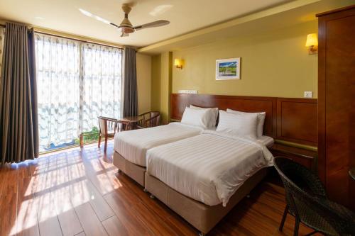 a bedroom with a large bed and a large window at Blue Wave Hotel Maldives in Kudahuvadhoo
